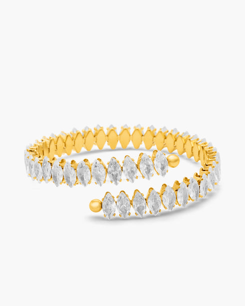 Gold bangle with clear gemstones on a white background